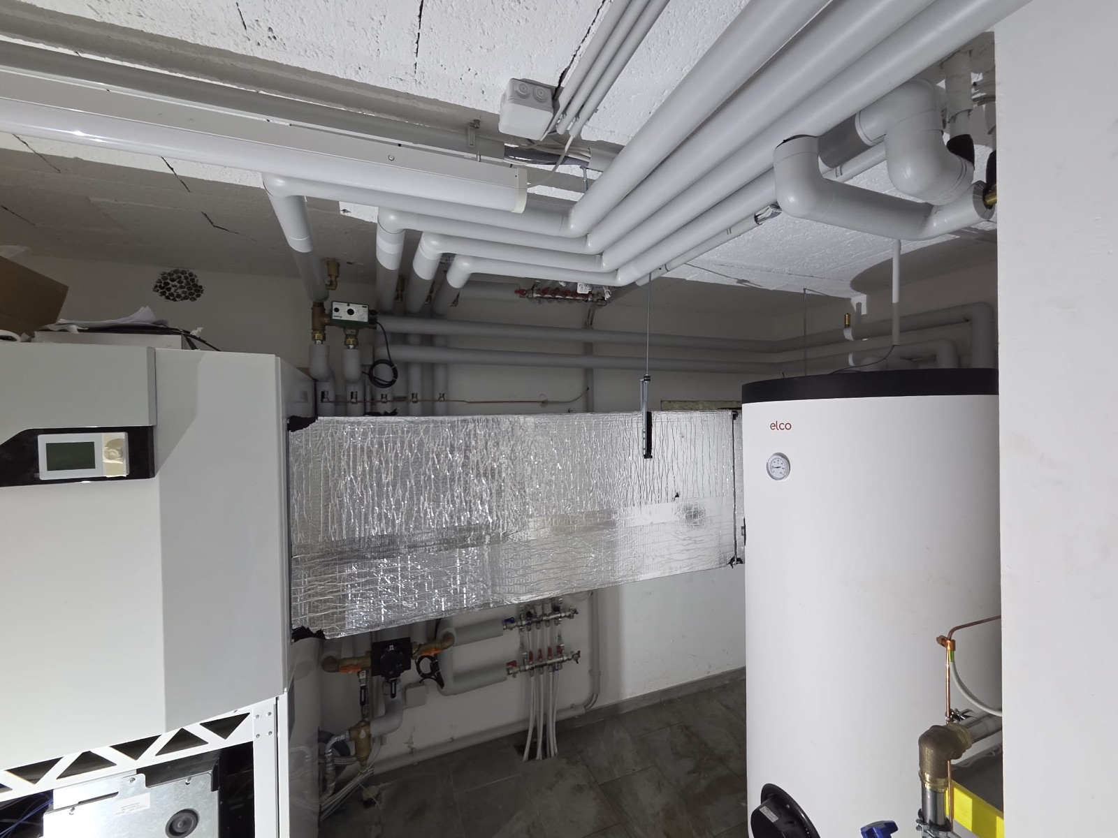 Chaufferie réalisée par GRD : boiler, conduites isolées et distribution de chauffage