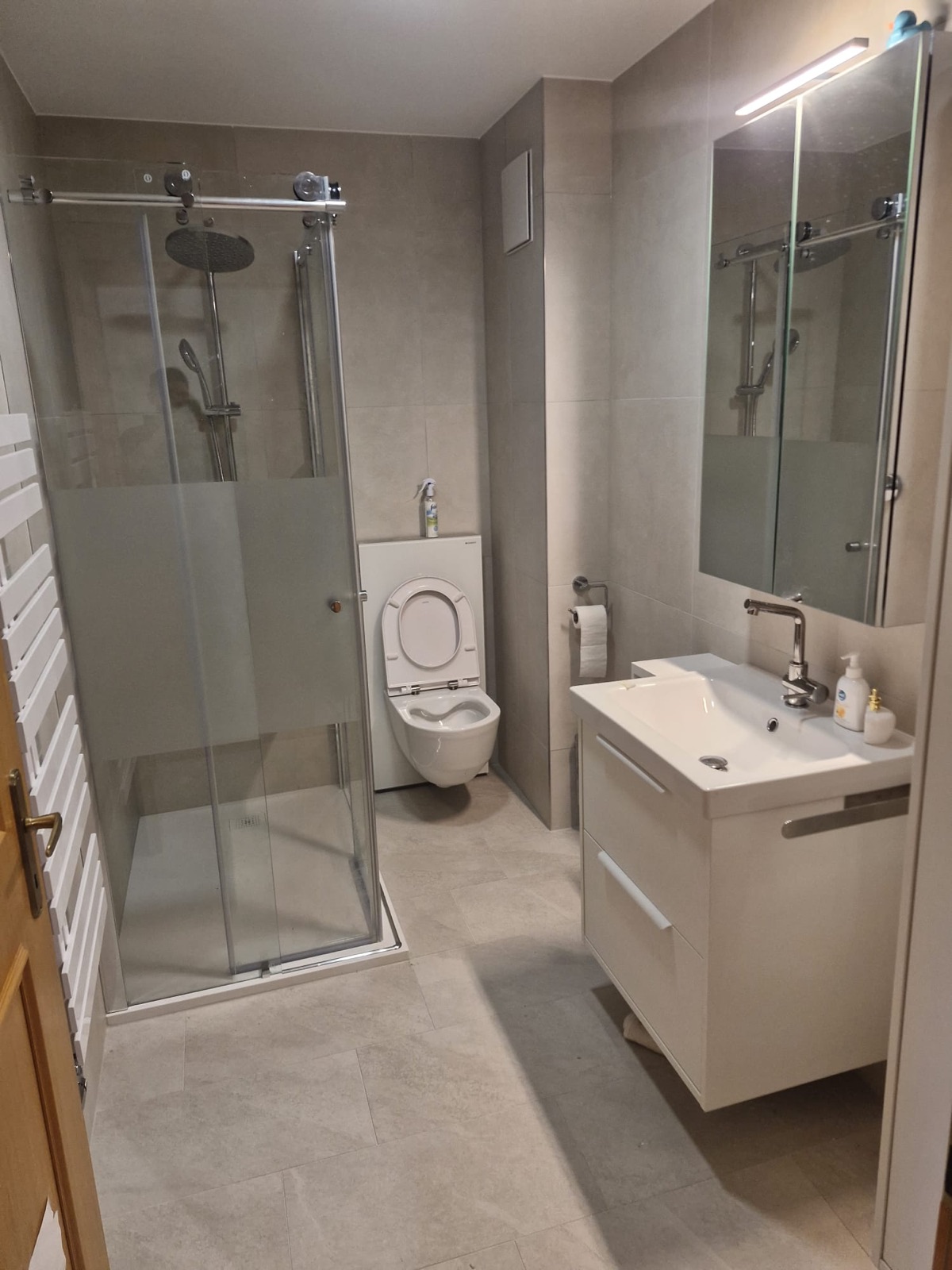 Salle d'eau installée par GRD : cabine de douche, WC suspendu et meuble vasque
