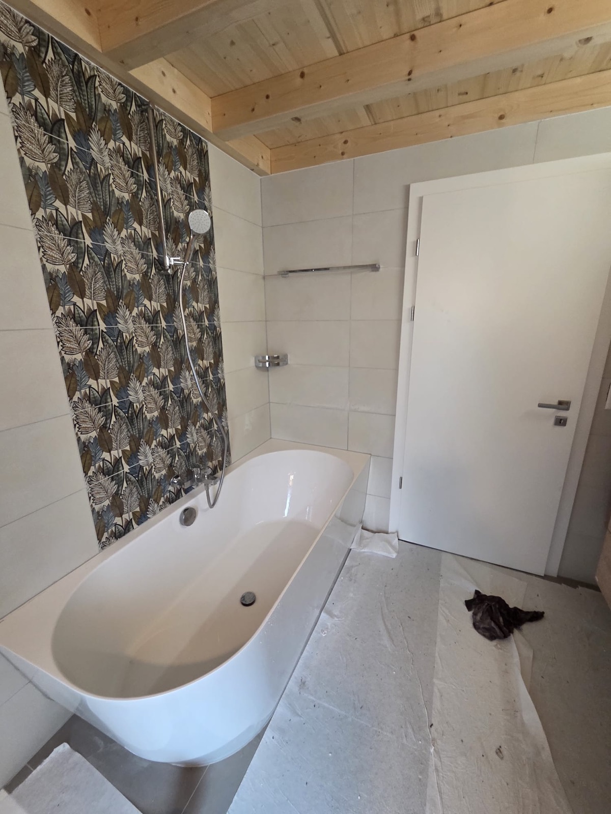 Rénovation de salle de bain par GRD dans un chalet : baignoire et faïence décorative sous plafond en bois